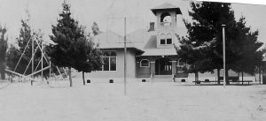 The same building is shown later with playground equipment in front. The building faced east, situated in the middle of the new property. -Elena Frackelton Murdock family.  