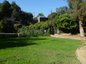 The connection between the upper park and campus road is shown. In the background are two of the neighboring homes. The neighbors are quite concerned about the condition of the park and efforts to revive its use.-Photo by Eric Warren, 10-13-2010.