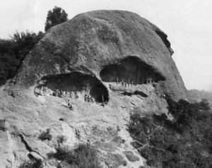Ersatz  'Indian' actors pose on the Eagle Rock on a movie shoot around 1920. The scale of the caves on the rock’s side is evident. (Marc Wanamaker-Bison Archives)