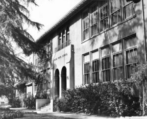 This photograph (ca 1965) of the Fair Park façade shows the changes made during the earthquake safety retrofit of 1934. The steel and original brick was covered with the stucco seen here. The original sign was preserved. This early retrofit preserved the handsome early buildings, the only Eagle Rock school buildings that were not torn down and replaced for earthquake safety in the 1970’s. -ERVHS