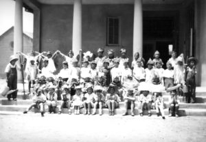 Costumed children are depicted in1929, on the steps of the original brick kindergarten building. Mrs. Anne Hare Harrison introduced the first “Harvest Home Festival”, commemorating Thanksgiving, in the fall of 1920. Put on by the PTA, it was a carnival occasion with food booths, games, and light and more serious stage entertainment. -ERVHS