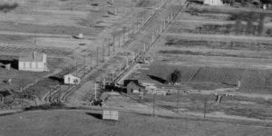 The same location in 1908. Commercial development and real estate sales (billboard in the foreground) had begun with the advent of the trolley (note the poles on Eagle Rock and Colorado Boulevards). A house is being moved down the middle of Colorado Boulevard. (ERVHS)