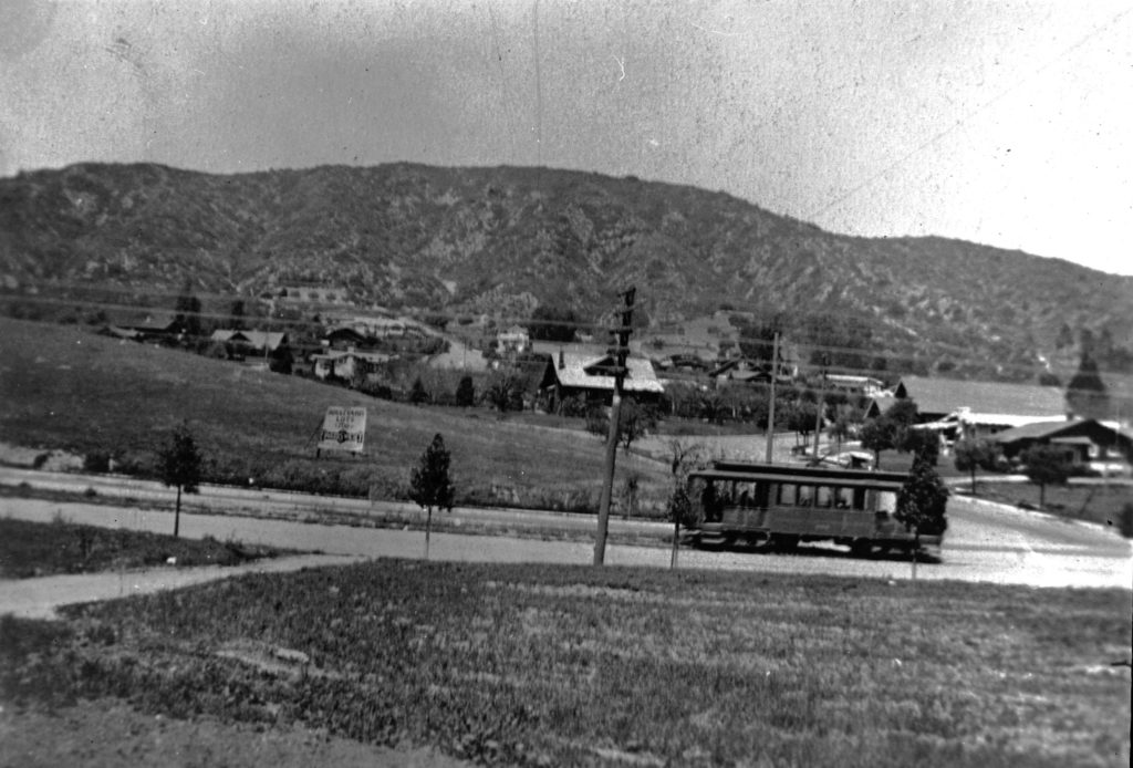 The streetcar heads west just past Ellenwood Drive. The sign advertises commercial lots on Colorado to be sold by Edwards and Winters. In later years, boys delighted in greasing the tracks, causing the car to slide backwards down the steep hill. (ERVHS) 